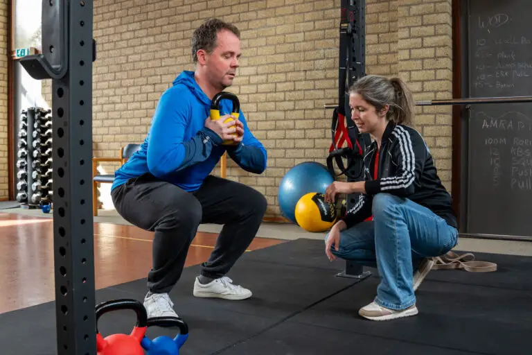 Man sport onder begeleiding van een fysiotherapeut