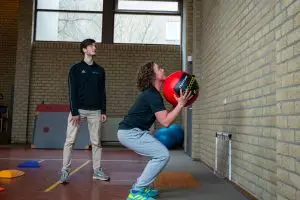 Sportblessures. Fysiotherapeut begeleidt man met sportgerelateerde klachten
