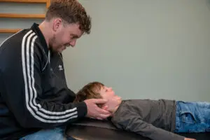 Kindermanueeltherapeut behandelt jong kind voor klachten aan de nek middels kindermanuele therapie