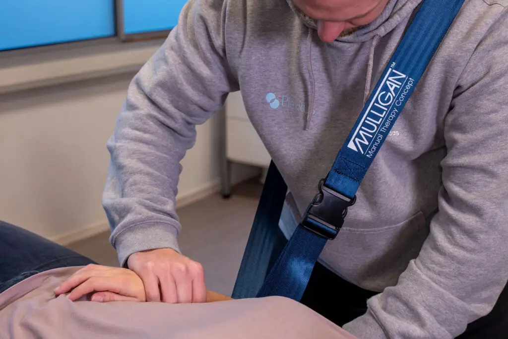 fysiotherapeut behandelt patiënt met mulligan therapie